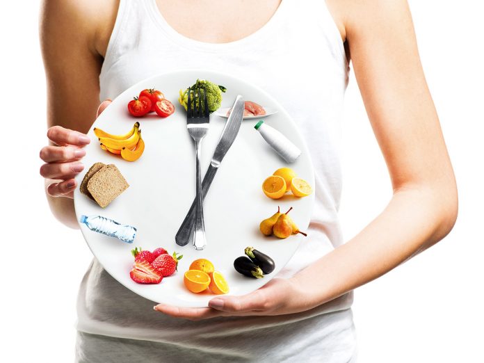 Beautiful young woman holding a plate with food