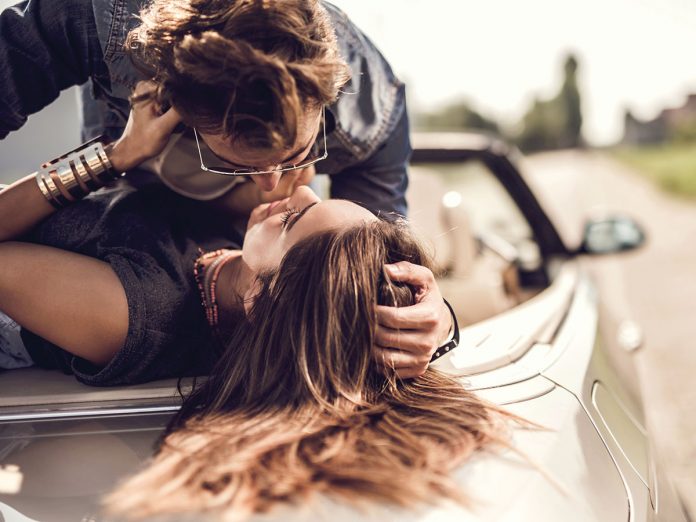 Young romantic couple enjoying in their love on a convertible.