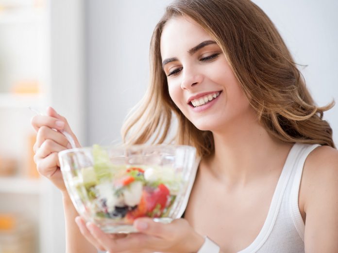 Nice joyful woman eating salad