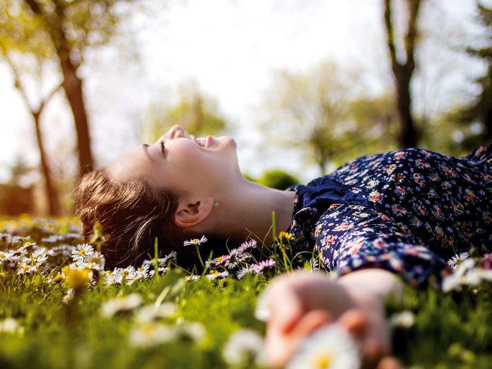 Pretty young teenage girl relaxing on a grass