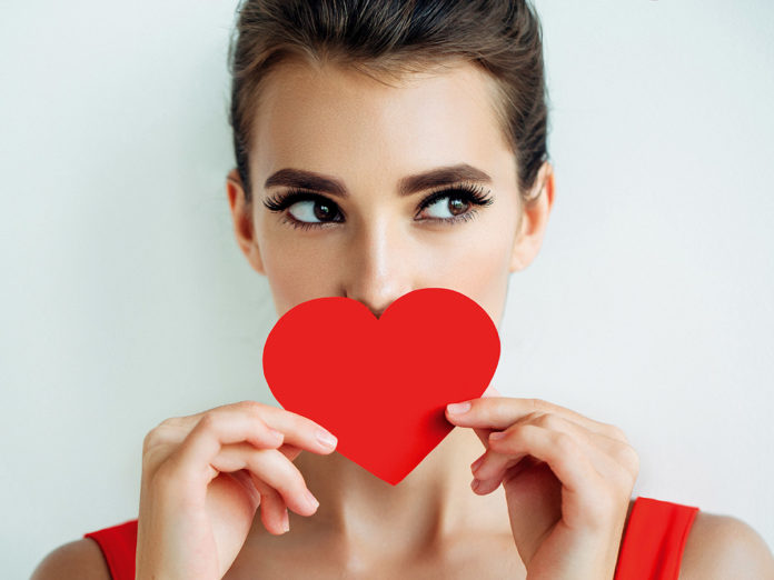 Beautiful girl holding artificial heart