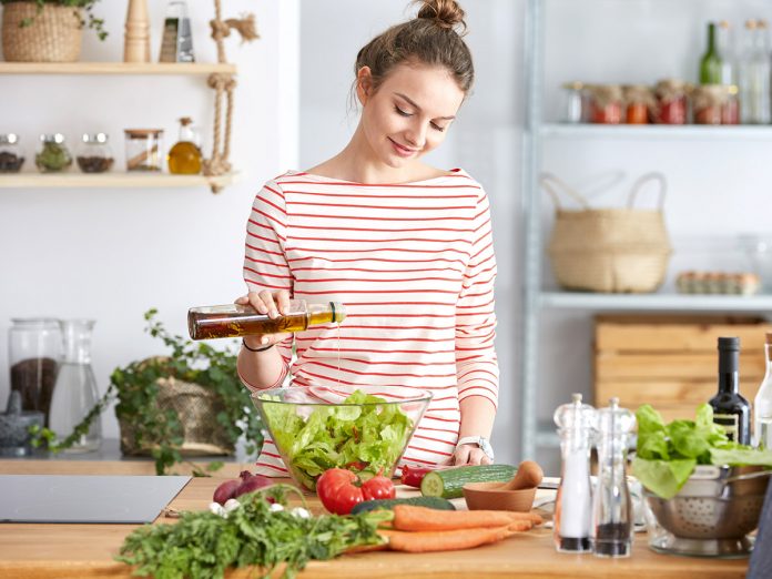 Adding olive oil to salad