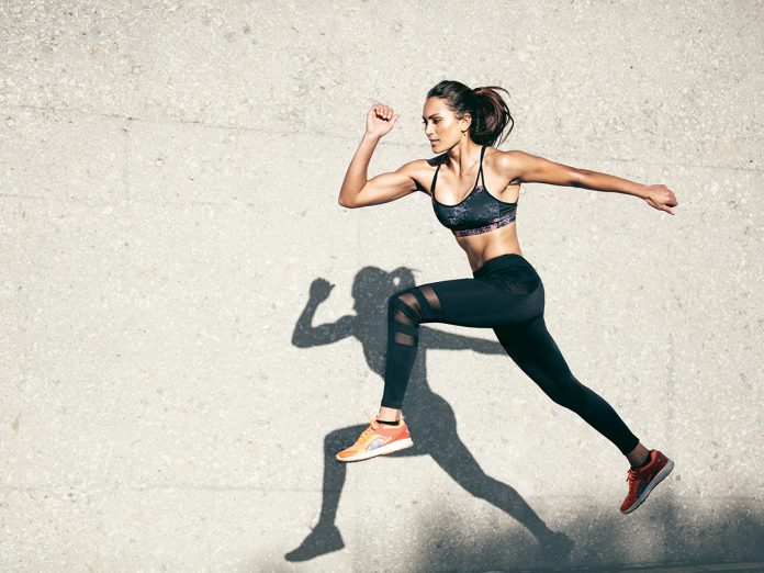 Fit young woman jumping and running