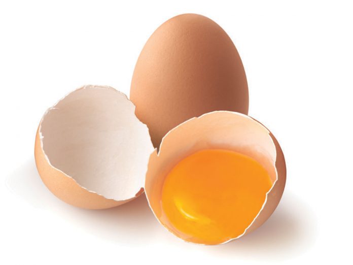A cracked, brown egg next to a whole one
