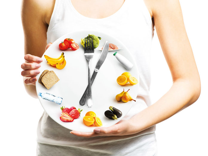 Beautiful young woman holding a plate with food