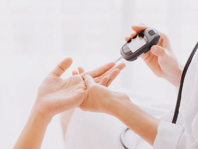 Doctor use glucosmeter with patient hand