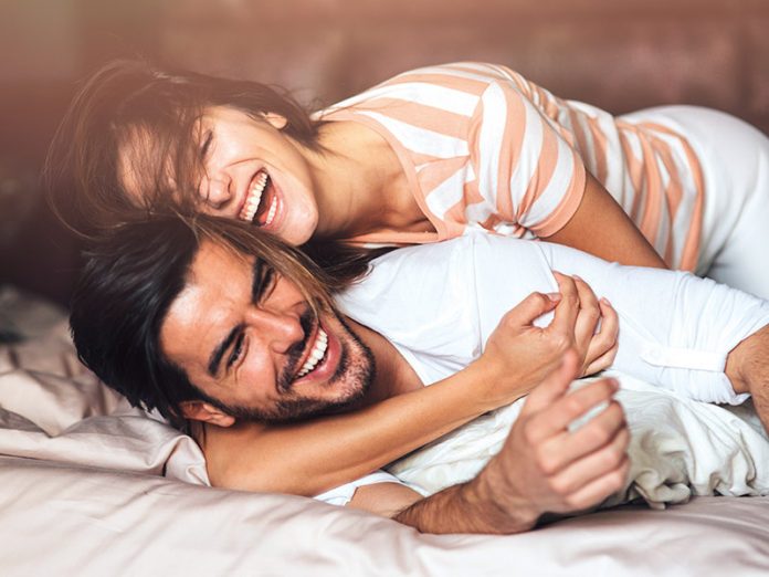 Happy young couple in bed