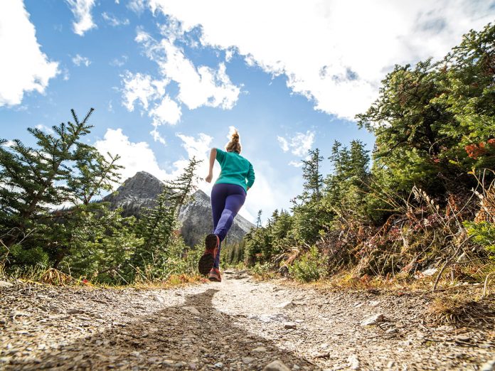 Young woman jogging on mountain trail