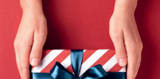 Hands holding striped gift box.